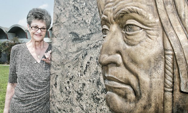 Joyce “Pale Moon” Krigsvold, a volunteer at the Pamunkey Indian Museum and Cultural Center on the reservation and an expert potter, stands near a likeness of the first Pamunkey chief, Powhatan, on the tribal grounds in King William County.