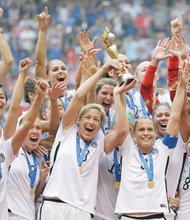The U.S. Women’s National Team celebrates with the trophy Sunday after they beat Japan 5-2 in the FIFA Women’s World Cup soccer championship in Canada.