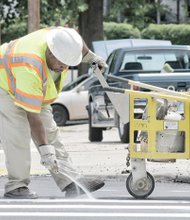 Antonio Hill, president of A&T Striping Co., puts the finishing touches on new roadway markings at a Richmond crosswalk. Location: Semmes Avenue and 34th Street on South Side. He and other companies have been called on to repaint markings on numerous streets. The city has been repaving many streets this year in preparation to host the international cycling championship in September. 