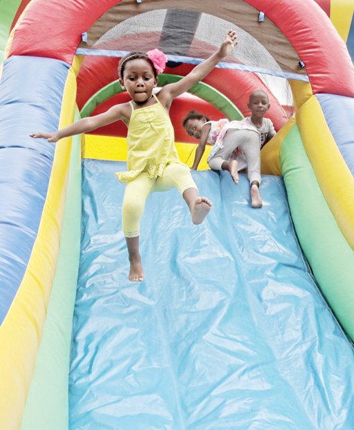 ONE GIANT LEAP-
All eyes are on 3-year-old Gabrielle Ba as she sails through the air and down a slide. She and her playmates were having fun Saturday at the 2nd Annual Brookland Park Boulevard History Festival on North Side. The free community event attracted hundreds of people and included entertainment, a farmer’s market, health screenings and lots of food and fun. Please see additional photos on B1.