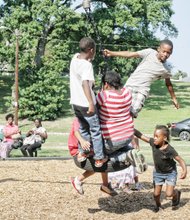 NORTH SIDE REUNION- Children climb aboard a swing at the playground