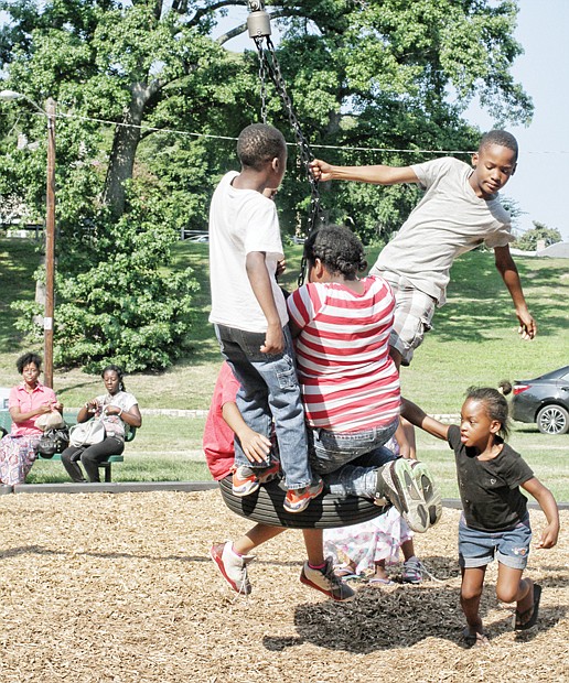 NORTH SIDE REUNION- Children climb aboard a swing at the playground