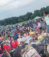 Food, fun and games for National Night Out- City Council President Michelle R. Mosby, 9th District, helps distribute backpacks filled with school supplies to audience members.