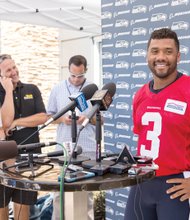 Seahawks quarterback Russell Wilson is all smiles at a training camp news conference last week following the announcement of successful negotiations extending Wilson’s contract with Seattle through 2019.