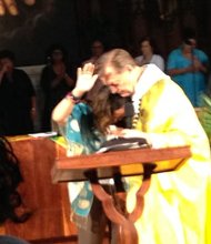 Father Michael Pfleger, pastor of  St. Sabina Church, comforts Lucia McBath,who lost a son to gun violence.