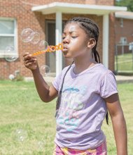 Tyleia Carter, 6, blows big bubbles saturday at the East End Get Fresh Fair and Farmers Market. The event was held on Accommodation street behind the Mosby Court Resource Center and offered a variety of nutritious vegetables and fruits for sale, as well as live music, games for children, health screenings and more.