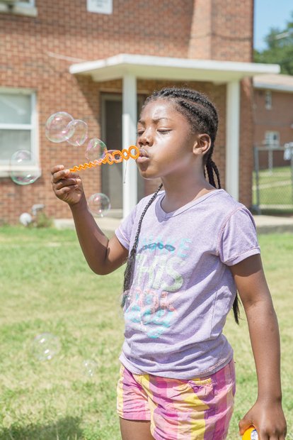 Tyleia Carter, 6, blows big bubbles saturday at the East End Get Fresh Fair and Farmers Market. The event was held on Accommodation street behind the Mosby Court Resource Center and offered a variety of nutritious vegetables and fruits for sale, as well as live music, games for children, health screenings and more.
