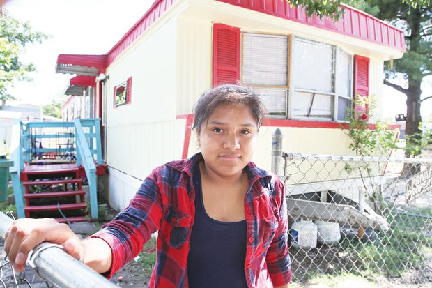 Olivia Leon Vitervo, standing in front of her family’s mobile home at Rudd’s Trailer Park last year, is a plaintiff in the lawsuit against the city.