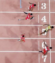 Overhead view shows Jamaican Usain Bolt (lane 5) edging American Justin Gatlin (lane 7) to claim 100-meter crown at the World Championships in China. This was Bolt’s third world title.
