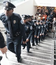 Proud graduates- Newly minted Richmond Police officers march from the Leslie Cheek Theater after being sworn in last Friday. Location: Virginia Museum of Fine Arts. The 30 officers are the city’s 111th recruit class. They hail from Virginia and states from Connecticut to North Carolina. They completed 30 weeks of training. They will spend the next eight weeks gaining field experience under the supervision of a veteran officer. The new officers are helping to fill some of the vacancies in the police department’s sworn contingent.