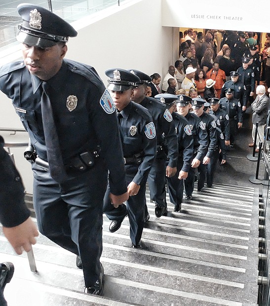 Proud graduates- Newly minted Richmond Police officers march from the Leslie Cheek Theater after being sworn in last Friday. Location: Virginia Museum of Fine Arts. The 30 officers are the city’s 111th recruit class. They hail from Virginia and states from Connecticut to North Carolina. They completed 30 weeks of training. They will spend the next eight weeks gaining field experience under the supervision of a veteran officer. The new officers are helping to fill some of the vacancies in the police department’s sworn contingent.