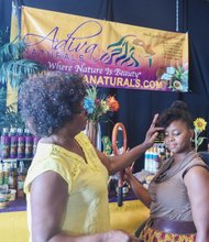 Happily Natural- Lucenia Thomas with Adiva Naturals products shows Tanetta Caleb the finer points and benefits of a hair care product. The two-day event is a business expo, cultural arts and crafts trade show designed to promote holistic health and social change. It also features performances by hip-hop, soul and spoken word artists.