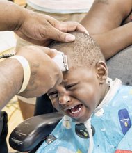 Desean Holland gets a back-to-school haircut from barber Donnell Bates.