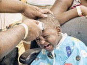 Desean Holland gets a back-to-school haircut from barber Donnell Bates.