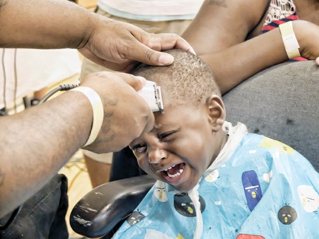 Desean Holland gets a back-to-school haircut from barber Donnell Bates.