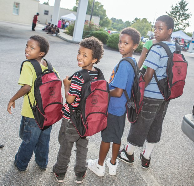 From left, Jandre, Nasir, Seneca and Jason Hackett are ready for the start of school with new book bags filled with school supplies. 