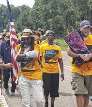 Journey for Justice marchers get a fist bump from a supporter as they walk through Moneta, S.C., last Sunday. The march that started in Alabama will swing through five states, including Virginia, before ending Sept. 16 in Washington. 