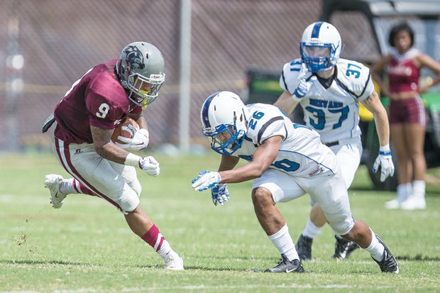 Virginia Union University freshman Hakeem Holland gets the ball past Brevard College opponents at Hovey Field, helping the Panthers to a 35-21 opening victory.  