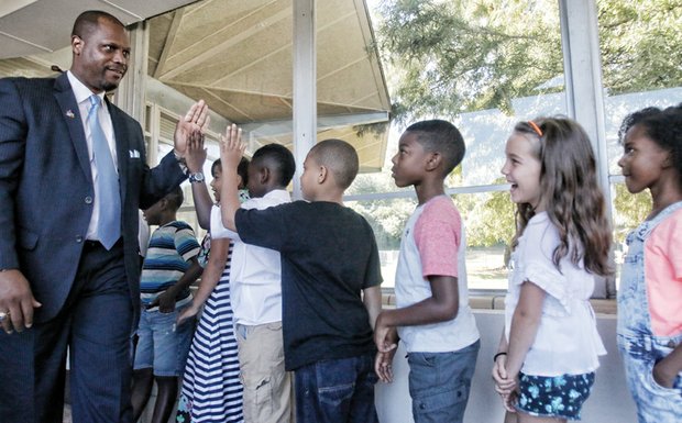 High-five for the new school year-Richmond Public Schools Superintendent Dana T. Bedden greets third-graders at J.B. Fisher Elementary School on South Side with high-fives on Tuesday, the first day of school. RPS officials reported a mostly smooth back-to-school launch for the nearly 24,000 students in pre-kindergarten through 12th grades. 
