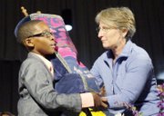 Elijah Coles- Brown, 11, receives the Torah — a Hebrew scroll of the five biblical books of Moses — from Rabbi Amy Schwartzman of Falls Church during the VUU stop on the NAACP’s “Journey for Justice.” The Torah accompanied marchers on the journey.