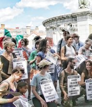 
Demonstrators signal their displeasure Saturday with the international bike races route along Monument Avenue with statues of Confederates who fought to enslave black people.