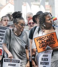 Queen Nzinga, left, and the Rev. Xika Esparza of Afro City Tours protest during last Saturday’s rally on Monument Avenue about the race route showcasing Confederate traitors.