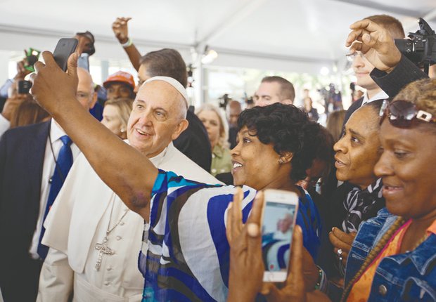 Cartrice Haynesworth takes a selfie with Pope Francis as he walks through the crowd during his visit last Thursday to Catholic Charities of the Archdiocese of Washington.