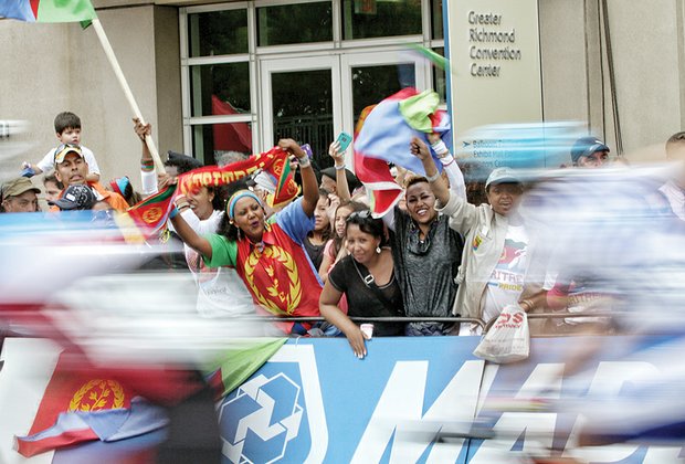 
Fans from the African nation of Eritrea wave their country’s flag as cyclists speed past them on Sunday during the Men’s Elite Road Race.