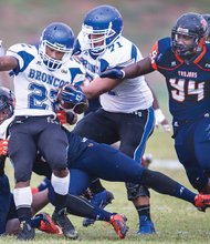 Virginia State University’s Daryl Simmons, left, takes down the Broncos’ Corbin Rascoe at Rogers Stadium in Ettrick last Saturday. The Trojans lost 33-20 to Fayetteville State University.