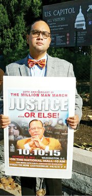 Raymond H. Boone Jr., Free Press vice president for new business development, displays a poster for the Justice Or Else national rally that drew people of all backgrounds, faiths and ethnicities to Washington.