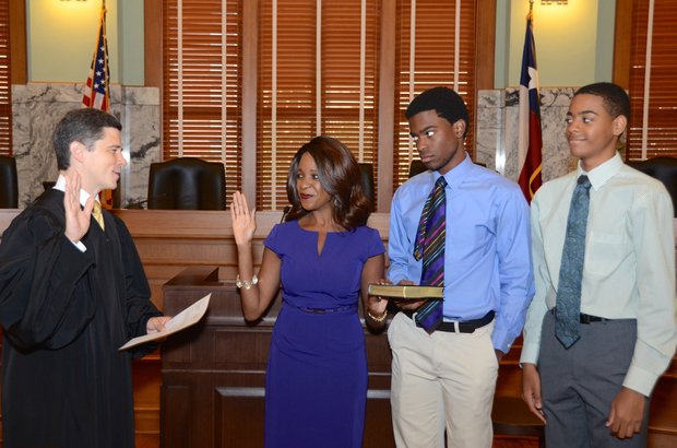Jacquie Baly is sworn into office by Justice Brett Busby her sons Raphael and Alex Chaumette by her side