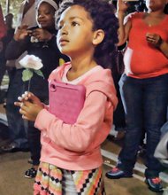 A show of love // 
Ama Aghomo holds a rose during the prayer vigil for Richmond’s “Ambassador of Compassion” Alicia C. Rasin at Jefferson Park in Church Hill. About 100 people gathered Oct. 15 to remember Ms. Rasin, who died Oct. 9. For more than two decades, Ms. Raisin organized prayer vigils for families of homicide victims in the city. She also provided food and clothes to the needy and gave gifts to children. 