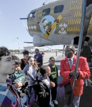 Flying history //
Otis Hooper of the Howard Baugh Chapter of Tuskegee Airmen in Petersburg explains how the renowned African-American airmen escorted bombers like
this B-17 Flying Fortress heavy bomber during important WWII missions. The youngsters participate in the chapter’s Youth in Aviation Program. They
met last Saturday at the Chesterfield County Airport, where vintage aircraft from WWII, including the B-17 bomber, were flown in for viewing and aerial tours. The chapter encourages youth education, particularly in STEM areas.