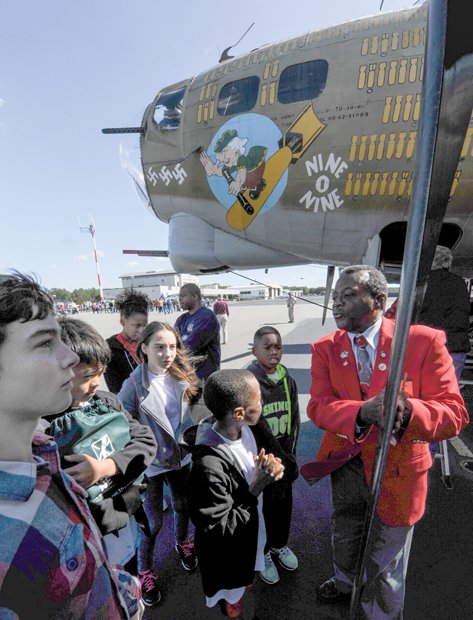 Flying history //
Otis Hooper of the Howard Baugh Chapter of Tuskegee Airmen in Petersburg explains how the renowned African-American airmen escorted bombers like
this B-17 Flying Fortress heavy bomber during important WWII missions. The youngsters participate in the chapter’s Youth in Aviation Program. They
met last Saturday at the Chesterfield County Airport, where vintage aircraft from WWII, including the B-17 bomber, were flown in for viewing and aerial tours. The chapter encourages youth education, particularly in STEM areas.