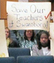 Teachers at Monday’s Richmond School Board meeting hold signs showing their opposition to the school administration’s plan to move some elementary school teachers from their current classrooms to other schools. 