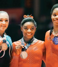 World Gymnastics champion Simone Biles, left, and second place winner Gabby Douglas show off their medals after the women’s all-around final competition Oct. 29 in Glasgow, Scotland.