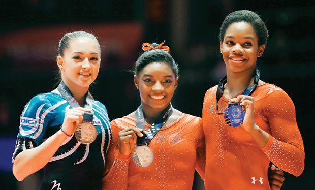 World Gymnastics champion Simone Biles, left, and second place winner Gabby Douglas show off their medals after the women’s all-around final competition Oct. 29 in Glasgow, Scotland.