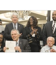 Gov. Terry McAuliffe, seated center, restores the voting rights of two felons who are rebuilding their lives, Chanté Hamlin, seated left, and Bobby Jack Blevins, seated right, during the state NAACP convention last weekend. Looking on, from left, are interim state NAACP Executive Director Jack Gravely, state Attorney General Mark Herring, outgoing state NAACP President Carmen Taylor and Henrico Delegate Lamont Bagby. 