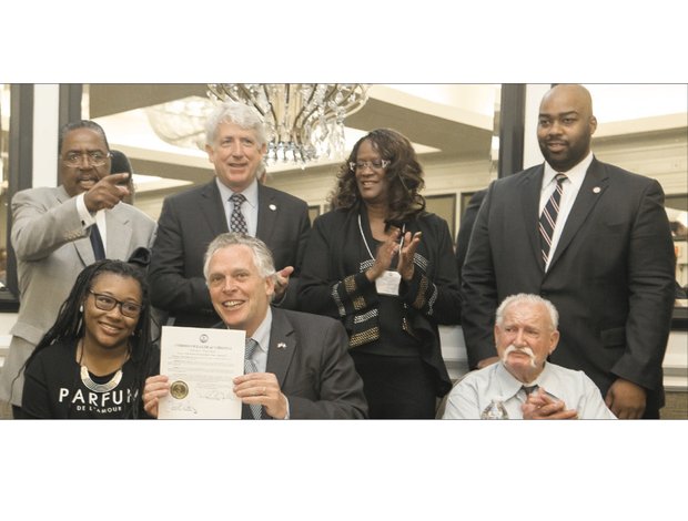 Gov. Terry McAuliffe, seated center, restores the voting rights of two felons who are rebuilding their lives, Chanté Hamlin, seated left, and Bobby Jack Blevins, seated right, during the state NAACP convention last weekend. Looking on, from left, are interim state NAACP Executive Director Jack Gravely, state Attorney General Mark Herring, outgoing state NAACP President Carmen Taylor and Henrico Delegate Lamont Bagby. 