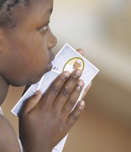 A youngster holds a prayer card from Pope Francis during a special Mass at a Roman Catholic parish in Kangemi, a slum in Nairobi, Kenya, that is home to 650,000 people. The pope will meet slum dwellers and refugees during his five-day visit beginning Nov. 25 to Kenya, Uganda and Central African Republic. 