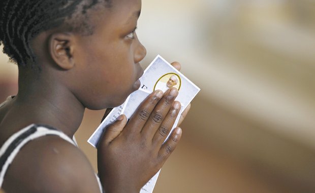 A youngster holds a prayer card from Pope Francis during a special Mass at a Roman Catholic parish in Kangemi, a slum in Nairobi, Kenya, that is home to 650,000 people. The pope will meet slum dwellers and refugees during his five-day visit beginning Nov. 25 to Kenya, Uganda and Central African Republic. 