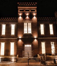 The new home of the Black History Museum and Cultural Center of Virginia at 122 W. Leigh St. comes alive in a public illumination ceremony last Friday. Craig Alexander Matthews, left, directs the Richmond Boys Choir during its performance at the outdoor event that drew about 125 people. 