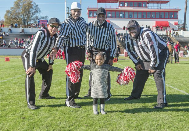 Are you ready for some football?
Three-year-old Mikenzie “Button” Williams recruits game officials for cheering duty last Saturday during halftime of the exciting Richmond Parks and Recreation Pee Wee Football championship game. The Battery Park Vikings defeated the Hotchkiss Eagles 6-0 in overtime, clinching the title for 9- and 10-year-olds at City Stadium. Championship matches also were played in four other age groups. Officials learning new cheers are, from left, William Jessie, Ellery Lundy, Rudy Waddell and Jimmy Drayton. 