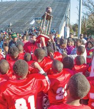 The Battery Park Vikings celebrate their 6-0 overtime victory to claim the Pee Wee Division trophy Saturday in the Richmond Parks and Recreation football championship at City Stadium.