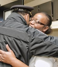 On Monday, two of Ms. Rasin’s sisters, from left, Albertina Walker and Tina Edwards, accompanied Richmond Acting Deputy Police Chief Steve Drew as he took a turkey and fixings to a family in the Richmond Dairy Apartments in Jackson Ward. Right, Chief Durham hugs Ladonna Thompson after Ms. Rasin’s sisters presented her with a Thanksgiving dinner basket.