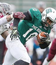 Virginia Union University linebacker Joshua Fasavalu, left, tries to get a grip on Slippery Rock University wide receiver Cornelius Raye during the Panthers’ first-round match last Saturday in the NCAA Division II football playoffs. The Panthers came up short 40-21.