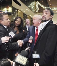 
Republican presidential front-runner Donald Trump is joined by a small group of pastors, including embattled Richmond Christian Center Senior Pastor Stephen A. Parson Sr., left, and Omarosa Manigault, a former contestant on Mr. Trump’s reality TV show “The Apprentice,” following Monday’s meeting at Trump Plaza in New York City.