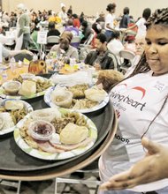 Thanksgiving Feast // Volunteer Alexis Harris carries a tray full of dinners to serve diners who enjoyed a free hot meal provided by Richmond area businesses and prepared and served by volunteers.