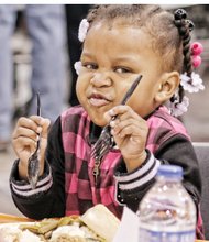 Thanksgiving Feast // Carlera Camp, 2, prepares to dig into her plate loaded with turkey and all the fixings on Thanksgiving Day at the 10th Annual Community Thanksgiving Feast at the Greater Richmond Convention Center in Downtown.