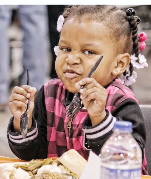 Thanksgiving Feast // Carlera Camp, 2, prepares to dig into her plate loaded with turkey and all the fixings on Thanksgiving Day at the 10th Annual Community Thanksgiving Feast at the Greater Richmond Convention Center in Downtown.